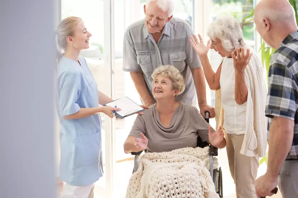 Senior woman on a wheel chair and her friends are having a conversation with a doctor / Une femme âgée en fauteuil roulant et ses amis discutent avec un médecin