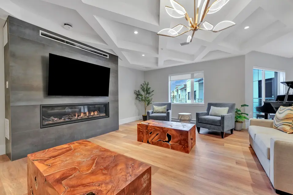 Cozy lounge with fireplace and TV at Edgewater by Chartwell / Salon chaleureux avec foyer et téléviseur à Edgewater par Chartwell