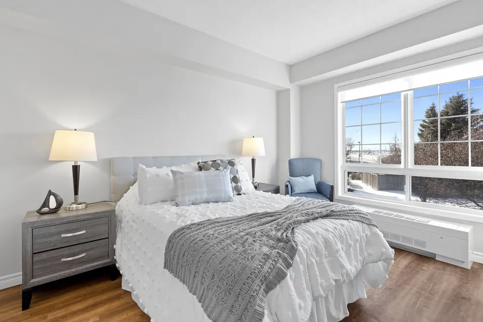 Bright bedroom with large window and modern décor at Chartwell Empress Kanata / Chambre lumineuse avec grande fenêtre et décor moderne à Chartwell Empress Kanata