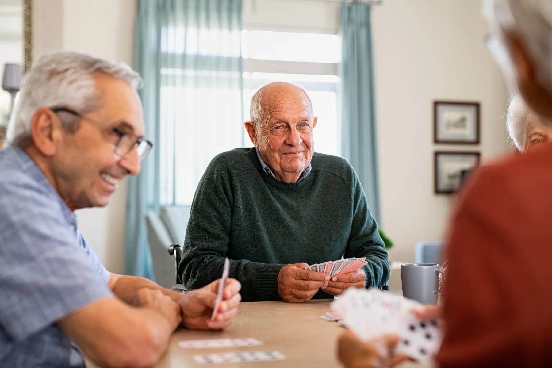 A group of seniors playing cards together / Un groupe de personnes âgées jouant aux cartes ensemble