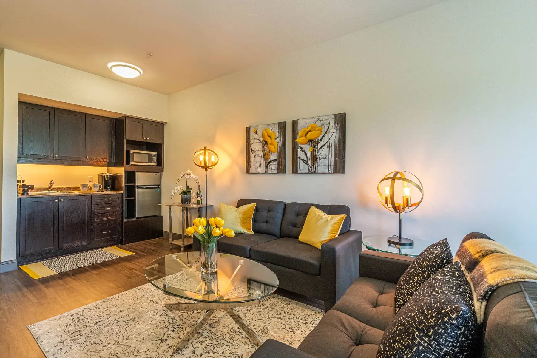 Chartwell Palermo Village model suite living room. This photo has a small kitchenette, couches and a coffee table.