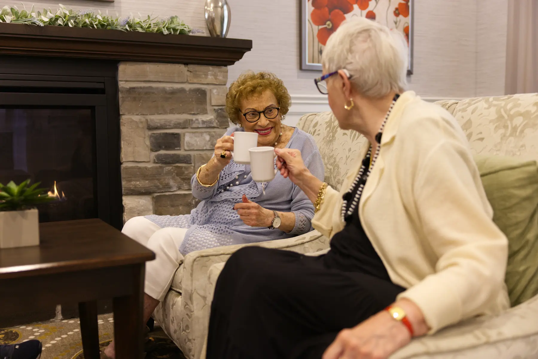 Two senior women posting their coffee cups with happy smile / Deux femmes âgées posant leurs tasses de café avec un sourire heureux