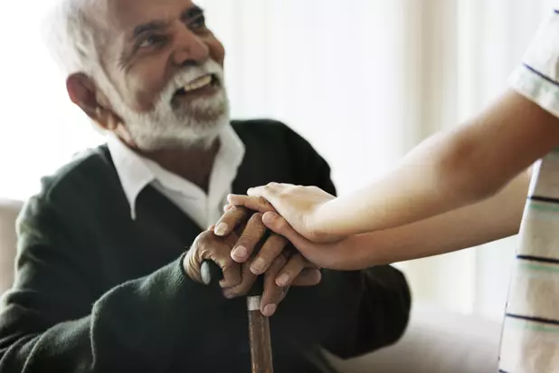 Senior holding hands with a grandchild during a supportive visit / Aîné tenant la main de son petit-enfant lors d’une visite de soutien