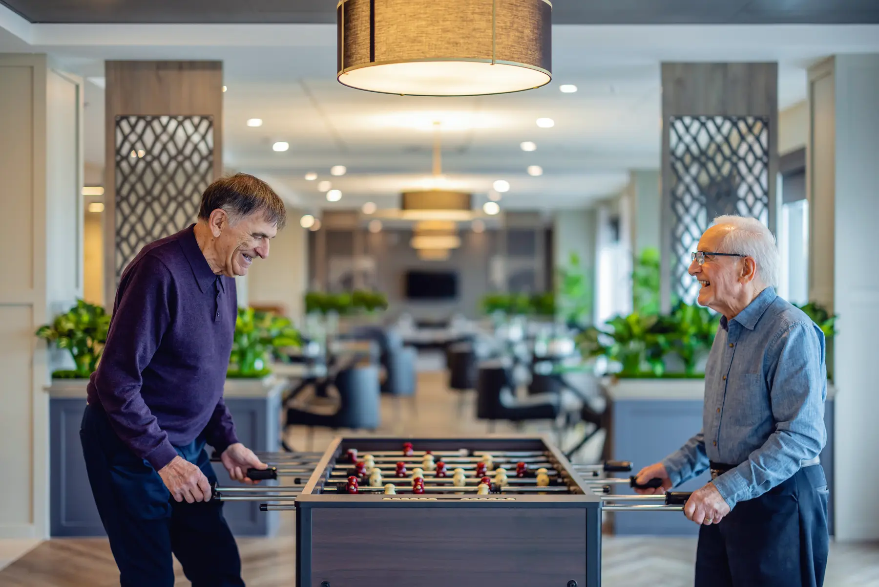 Seniormenareenjoyingplayingtablesoccer/Lesseniorss'amusentàjoueraubaby-foot