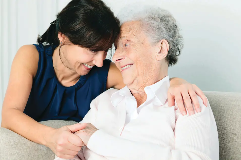Woman looking into her senior mom's eye with love / Une femme regardant sa mère âgée dans les yeux avec amour