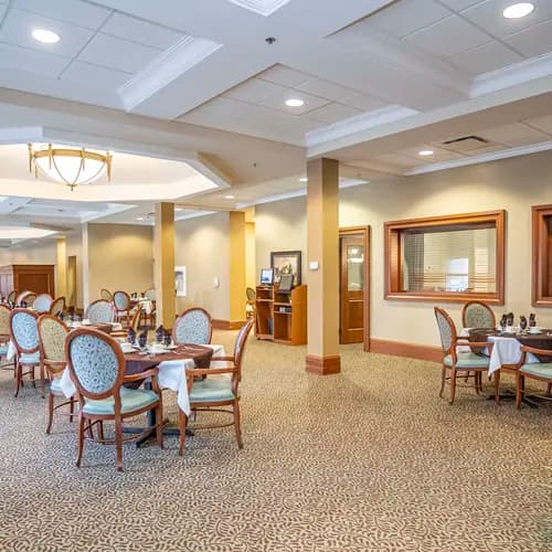 Elegant dining room with formal table settings and high ceilings at Chartwell Westhill / Salle à manger élégante avec tables dressées et hauts plafonds à Chartwell Westhill