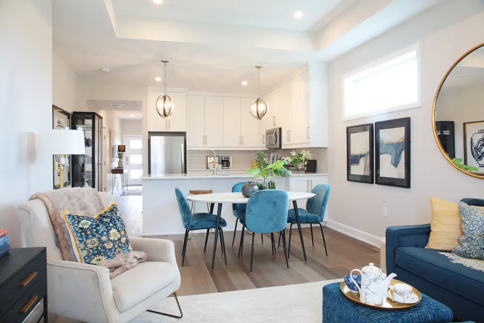 Open‑concept living and dining area beside bright kitchen at Chartwell Riverstone Villa / Aire ouverte avec salon et salle à manger adjacents à une cuisine lumineuse à Chartwell Riverstone Villa