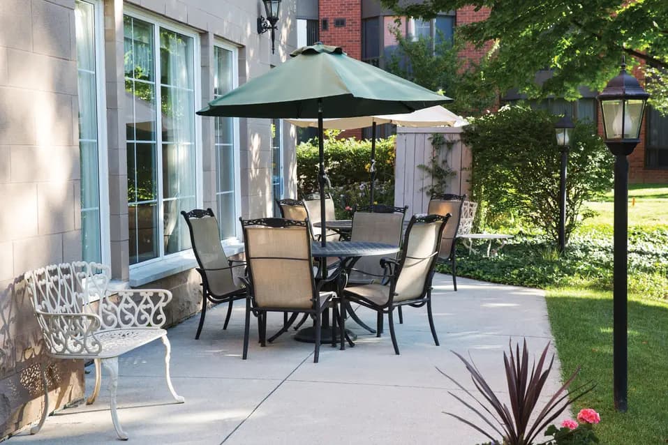 Outdoor patio with umbrella table and garden seating at Martha’s Landing / Terrasse extérieure avec table à parasol et sièges de jardin à Martha’s Landing