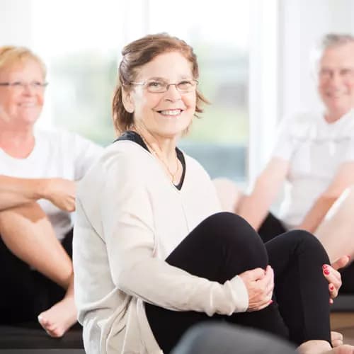 Smiling senior woman in comfortable yoga clothes participating into a fitness class / Les communautés Chartwell de l'Alberta près de chez moi