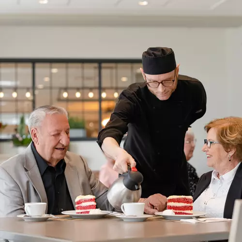 Chartwell staff server serving coffee/tea and dessert to the Chartwell senior residents in Dinning room