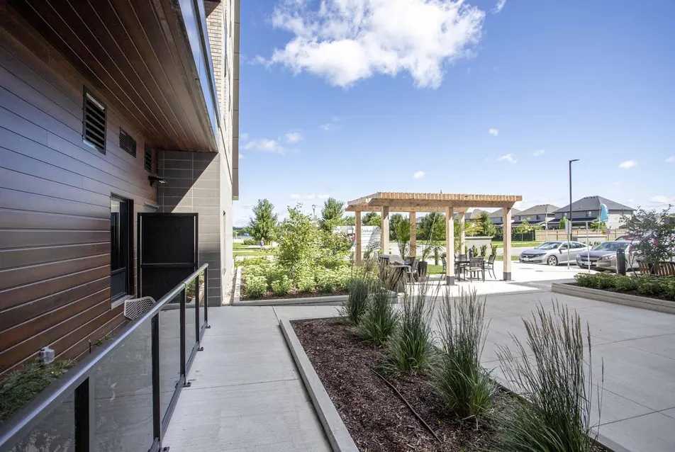 Outdoor patio with pergola and garden landscaping at Chartwell Riverstone / Terrasse extérieure avec pergola et aménagement paysager à Chartwell Riverstone