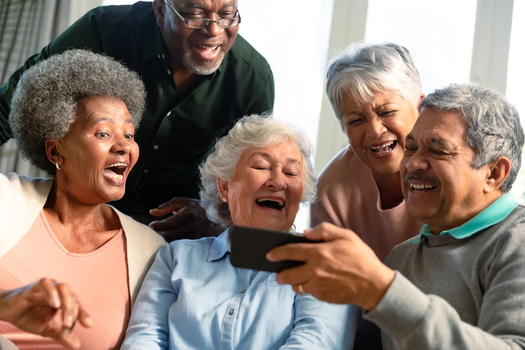 senior-friends-looking-at-phone 1