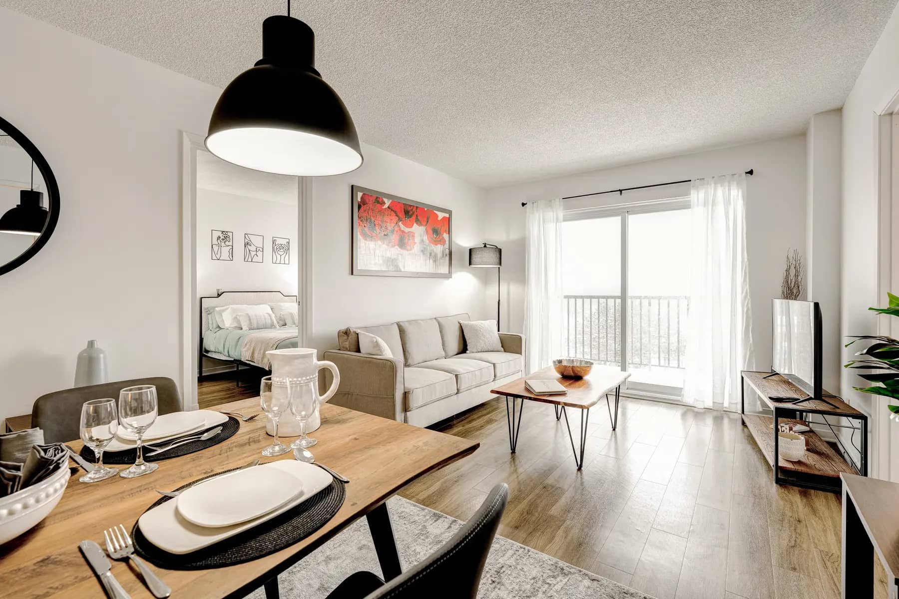 Espace repas et salon avec vue sur balcon à Chartwell Les Tours Angrignon / Dining and living area with balcony view at Chartwell Les Tours Angrignon