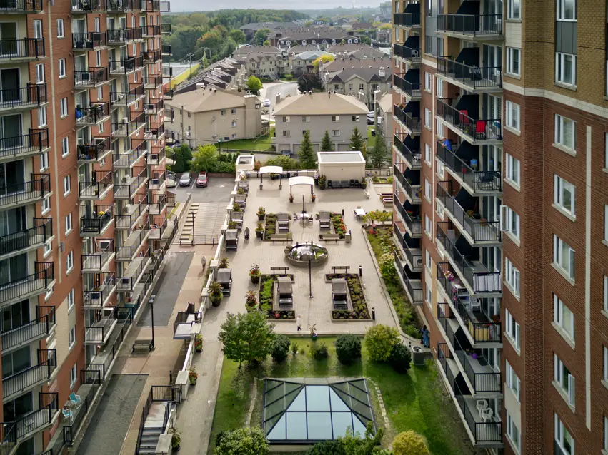 Vue aérienne entre les bâtiments donnant sur la terrasse de Chartwell Les Tours Angrignon / Drone view between buildings looking at terrace at Chartwell Les Tours Angrignon