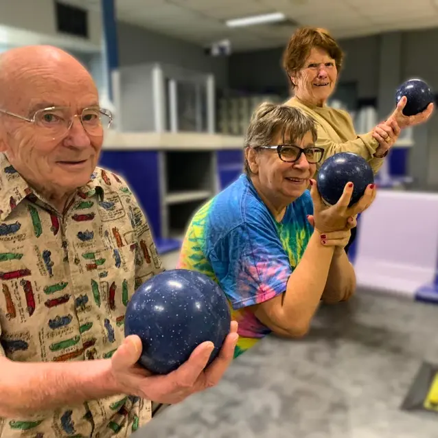 Senior man and women holding small bowling balls in their right hands