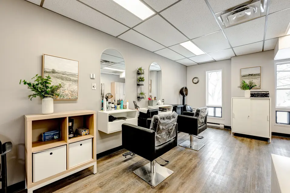 Salon de coiffure lumineux avec postes de coiffage à Les Écores / Bright hair salon with styling stations at Les Écores