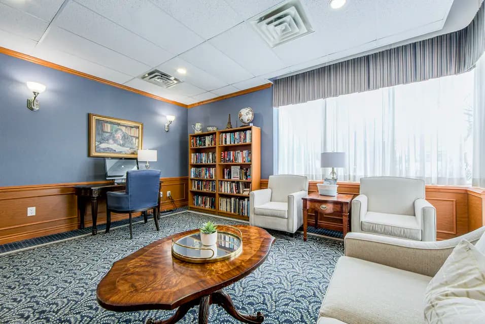 Lounge with book shelves, computer and couches at Chartwell Pickering City Centre / Salon avec étagères, ordinateur et canapés chez Chartwell Pickering City Centre
