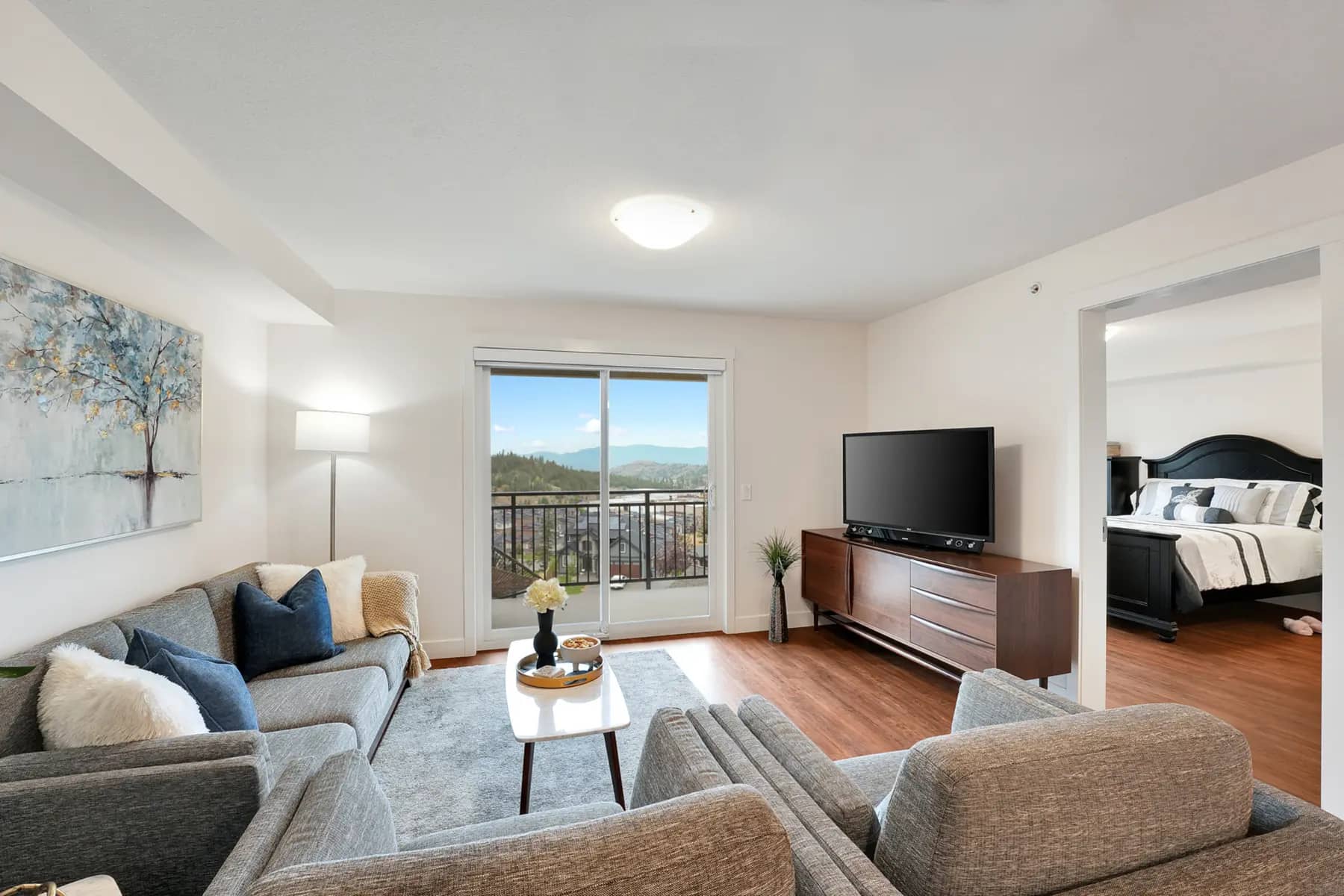 View of living room with the window to balcony, and entrance to the bedroom at Chartwell Ridgepointe / Vue du salon avec la fenêtre donnant sur le balcon et l'entrée de la chambre à Chartwell Ridgepointe