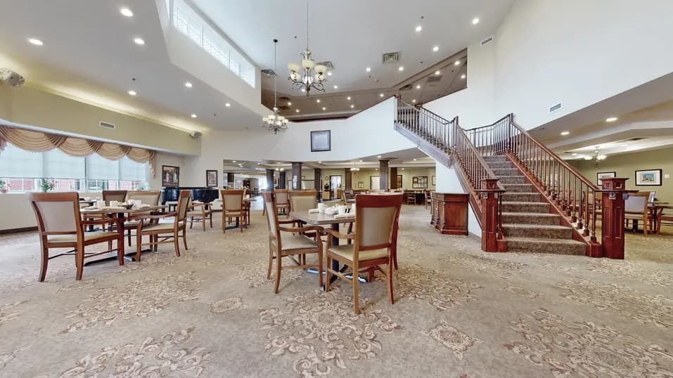 Dining room with table, chairs and staircase at Chartwell Franklin Park