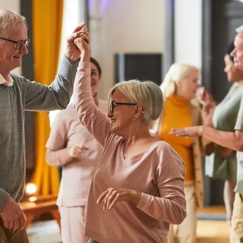 Group of smiling senior people dancing while enjoying activities in retirement home, copy space
