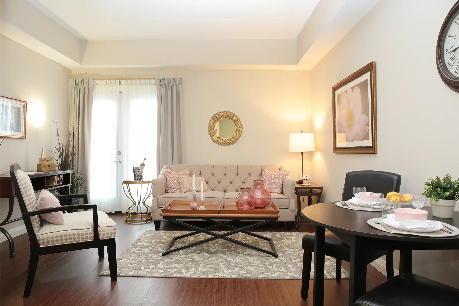 Warm living and dining space with neutral tones and tufted sofa at Chartwell Dorchester Terrace / Espace salon et repas chaleureux aux tons neutres avec canapé capitonné à Chartwell Dorchester Terrace