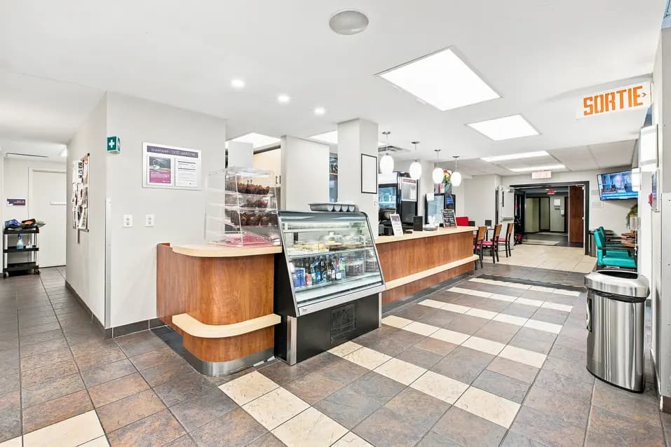 Bistro avec comptoir de service et espace de restauration au Chartwell Cité-Jardin. / Bistro with service counter and dining area at Chartwell Cité-Jardin.