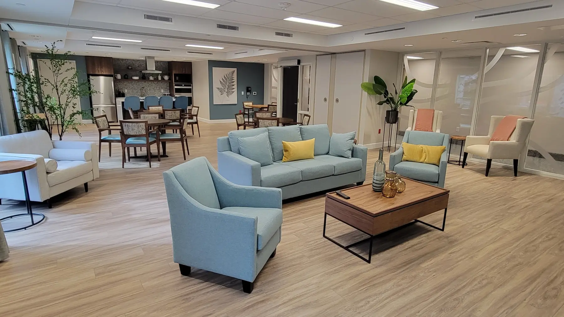 Spacious common area with seating and kitchen space at Chartwell Riverstone / Aire commune spacieuse avec espace cuisine et coin salon à Chartwell Riverstone