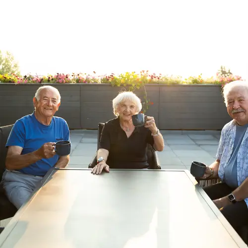 senior-woman-and-men-sitting-at-table-outdoors