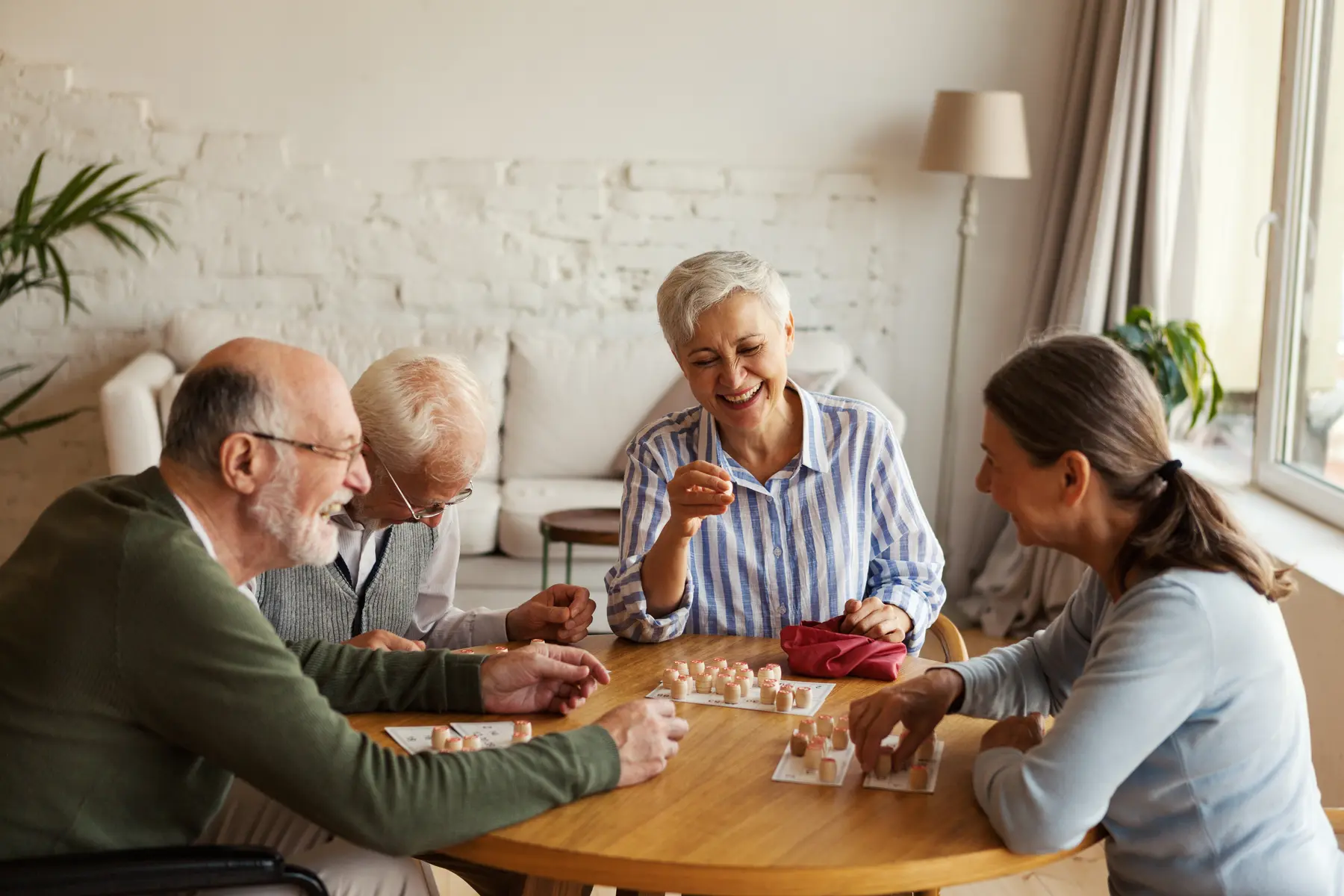 Seniorssittingatatableplayingagametogether