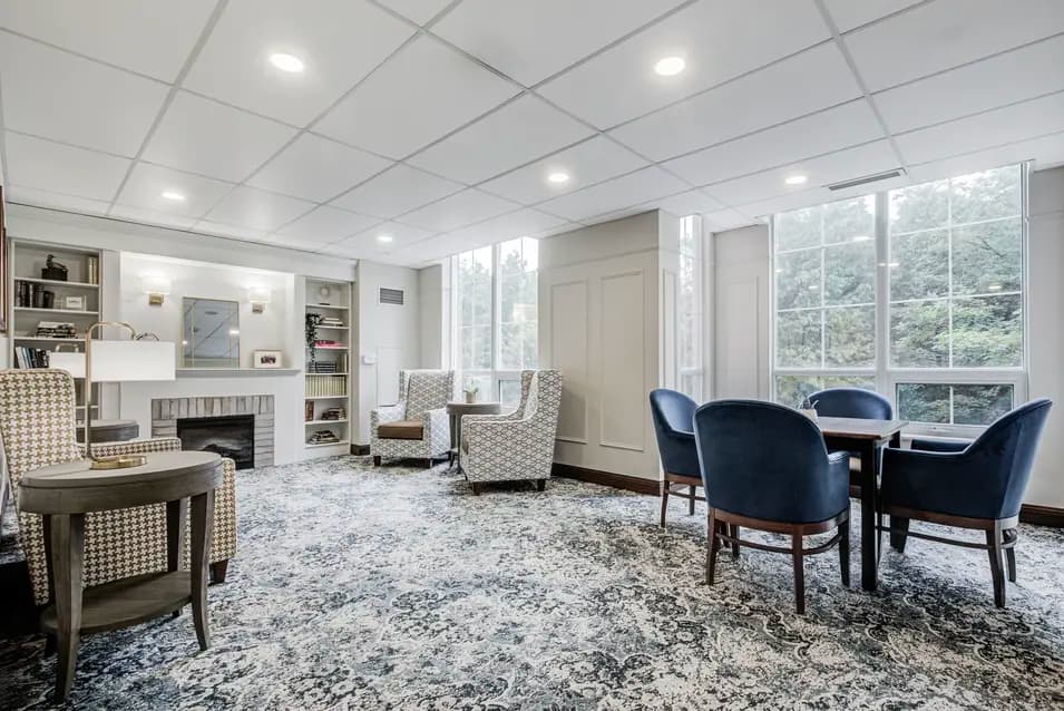 Fireside lounge with comfortable seating and forest views at Chartwell ValleyVista / Salon avec foyer, sièges confortables et vue sur la forêt à Chartwell ValleyVista