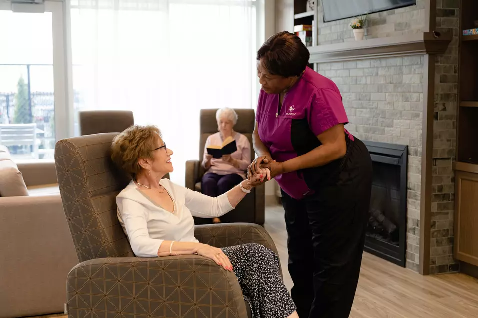 Chartwell care staff holding hand of a senior resident