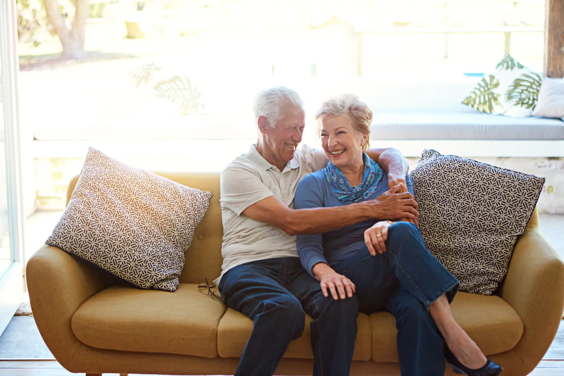 Love, smile or elderly couple on sofa with hug, connection or bonding together in retirement. Happy, senior man or woman on couch with embrace, marriage commitment or relationship security at home