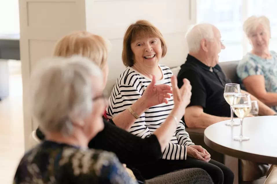 Seniors are having a light and joyful conversation while having some drinks / Les personnes âgées ont une conversation légère et joyeuse autour d'un verre