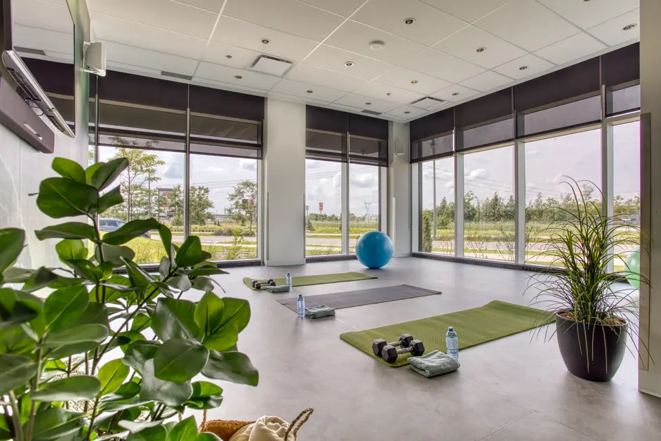 Salle de sport avec de grandes fenêtres à Chartwell Des Milles-Îles / Gym room with wide windows at Chartwell Des Milles-Îles