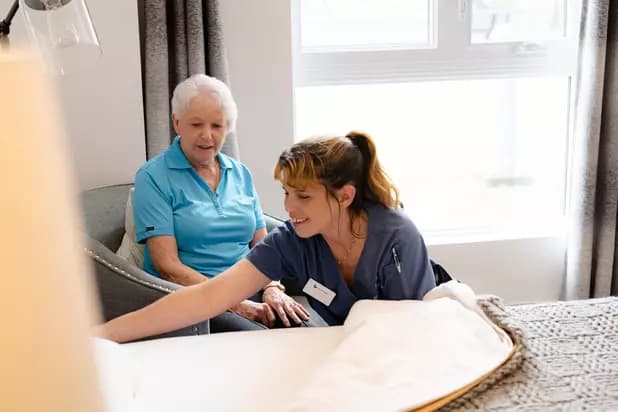 Chartwell staff helping the senior resident to make her bed