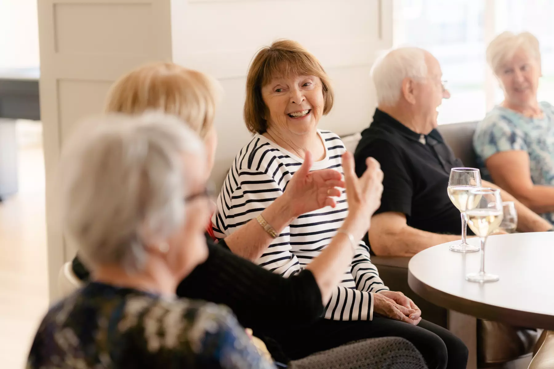 Senior residents chatting and enjoying a glass of wine