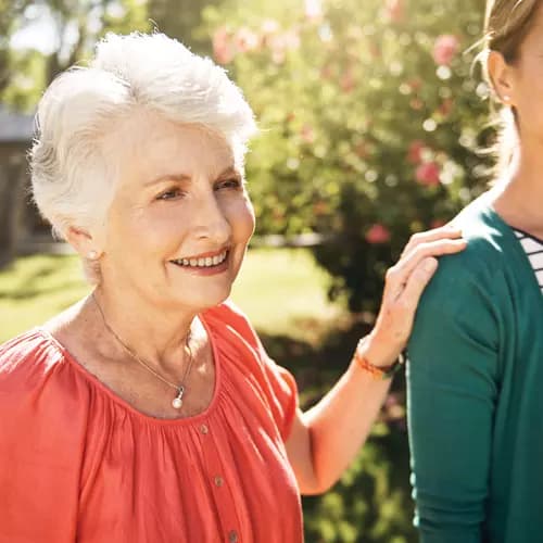 Senior woman with her hand on her daughter's shoulder. Femme âgée posant la main sur l'épaule de sa fille