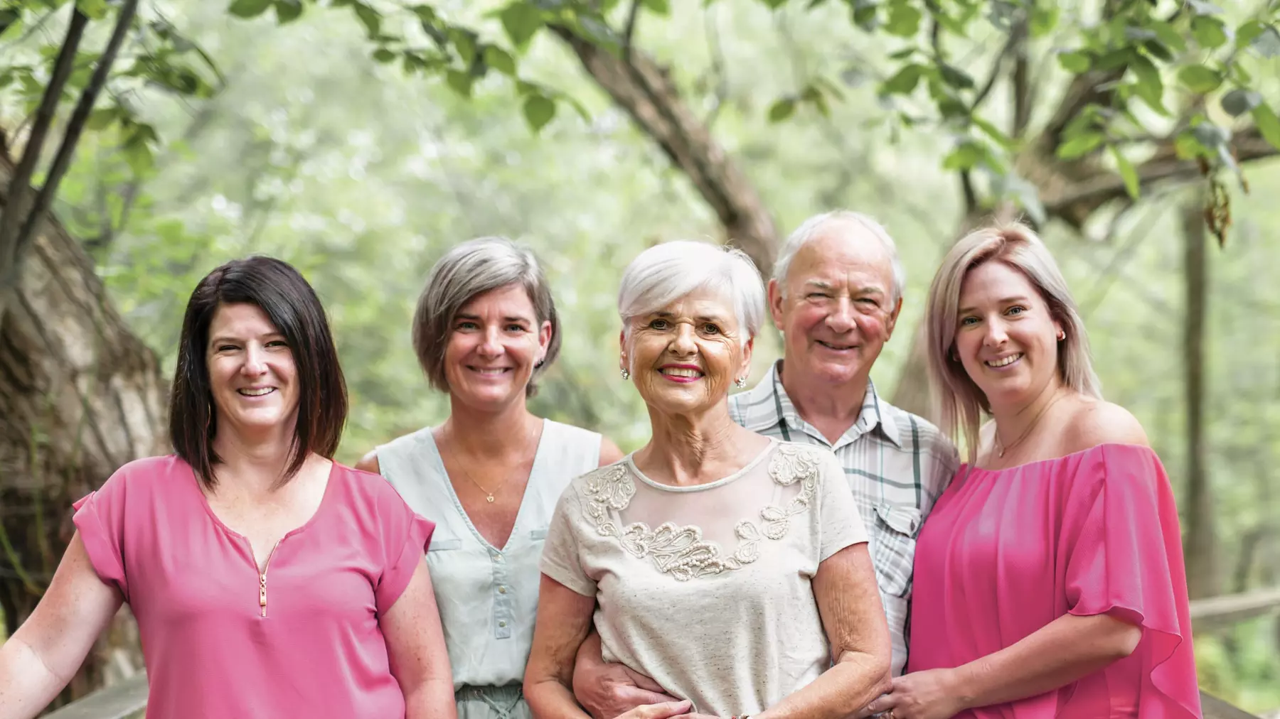 Senior couple with their three daughters on a bridge. Couple de seniors avec leurs trois filles sur un pont