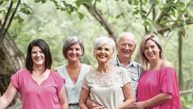 Senior couple with their three daughters on a bridge. Couple de seniors avec leurs trois filles sur un pont