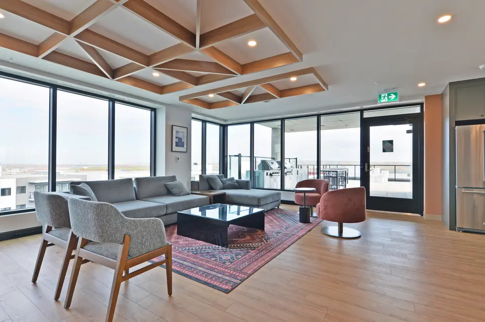 Salon avec canapés et larges fenêtres de l'appartement Le Jules-Verne / Lounge with sofas and wide windows at Le Jules-Verne Apartment