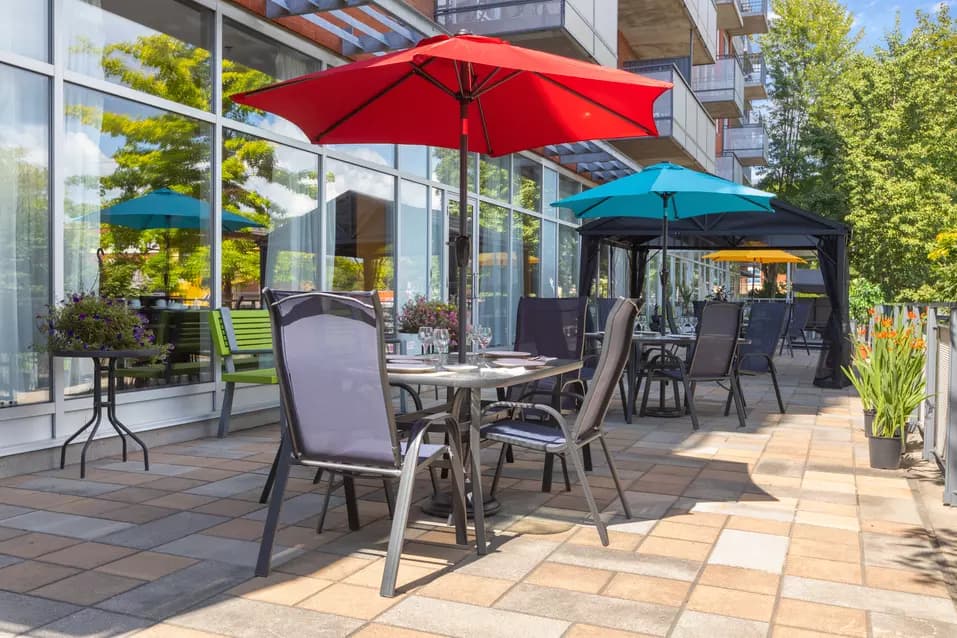 Terrasse avec table et parasols Chartwell Jardins Notre-Dame résidence pour retraités retirement residence terrace with table and parasol