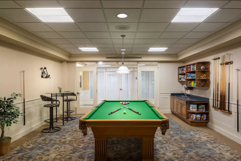 pool table lounge with stools at chartwell langley gardens assisted living