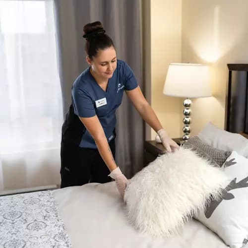Housekeeper at Chartwell retirement residence is organizing a bed for resident / L'aide ménagère de la maison de retraite Chartwell organise un lit pour un résident