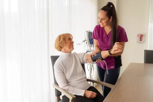 Chartwell staff is taking a blood pressure of a resident / Le personnel de Chartwell prend la tension artérielle d'une résidente