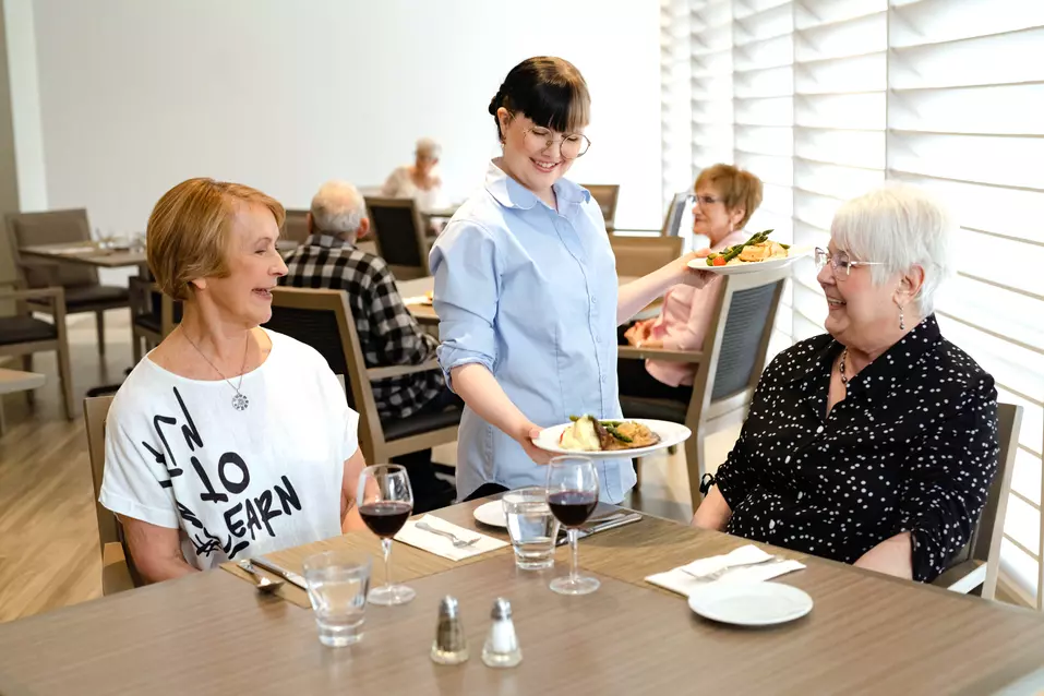 Chartwell staff server serving food to the Chartwell senior residents in Dinning room