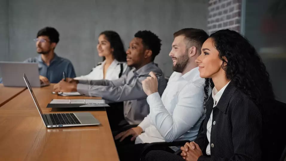 Diverse multiracial office workers multiethnic partners employees investors team watching presentation listening webinar business lecture presentation startup project corporate studying in boardroom. High quality photo