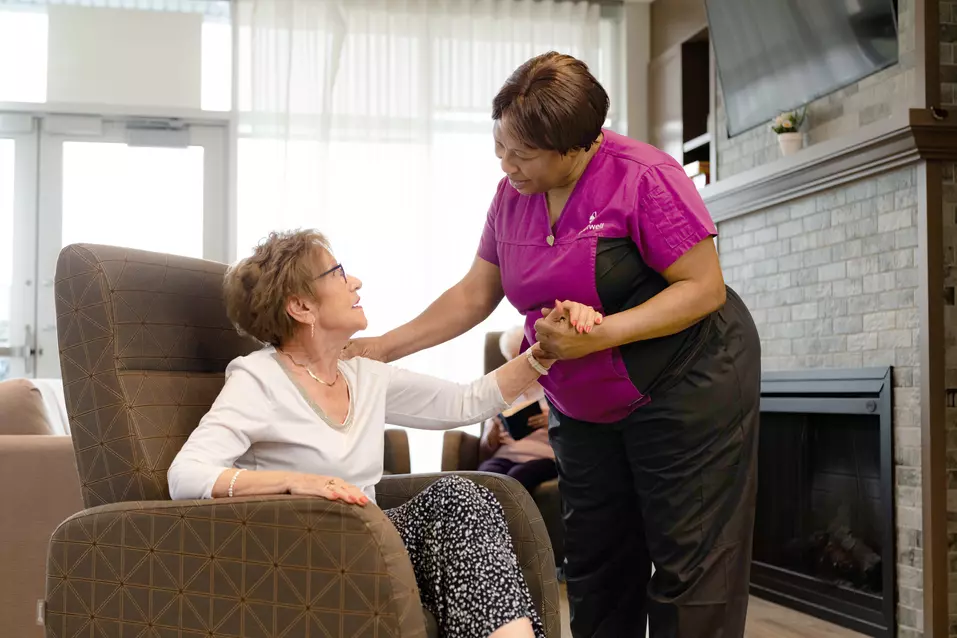 Chartwell Care staff chatting with the senior resident by the fire place